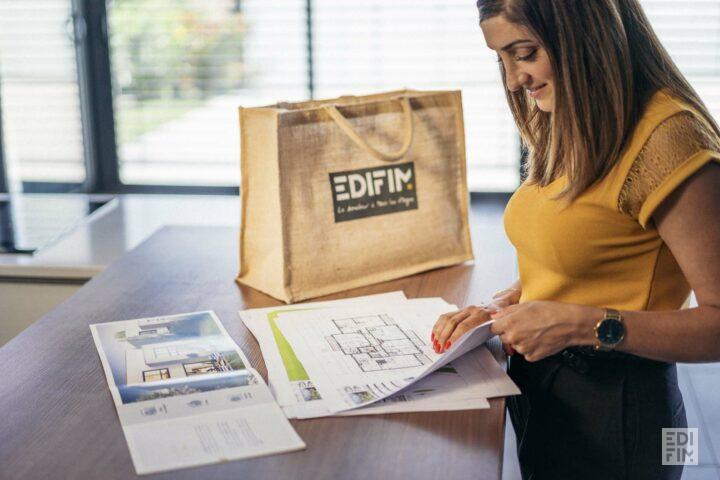 Une personne consulte le plan d'un appartement neuf.