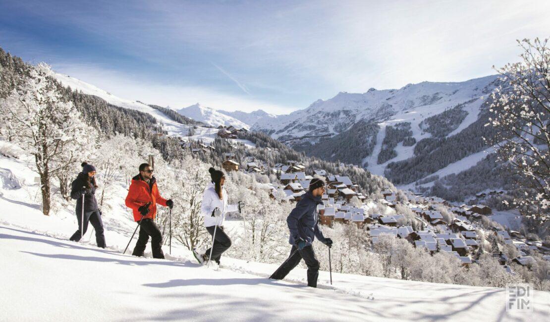 Photo illustrant des personnes en raquettes se promenant dans la montagne enneigée.