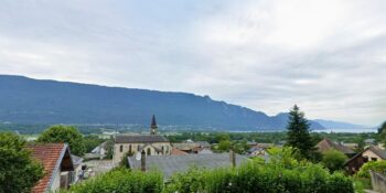Le village de Voglans avec une vue sur les montagnes et le lac du Bourget.