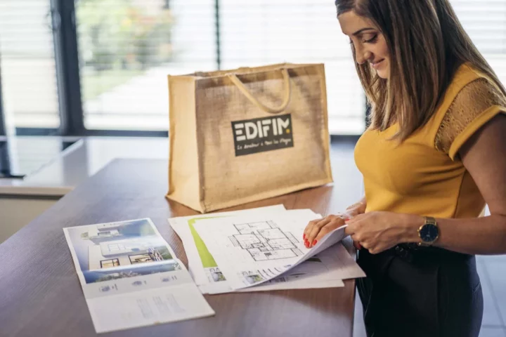 Une personne consulte le plan d'un appartement neuf.